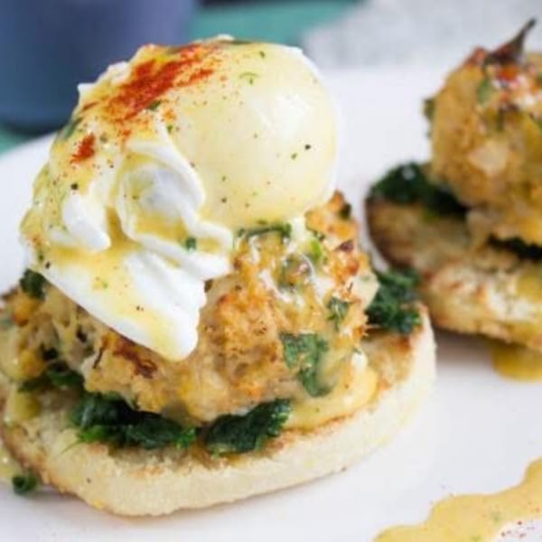 Sienna & Hope's Eggs Benedict with crab cakes, poached eggs, hollandaise sauce, and paprika.